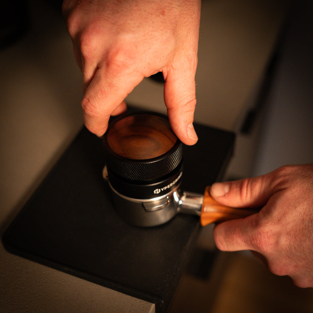 Hypergrind Gravity Distributor Tool (Black/Walnut) being used on a portafilter