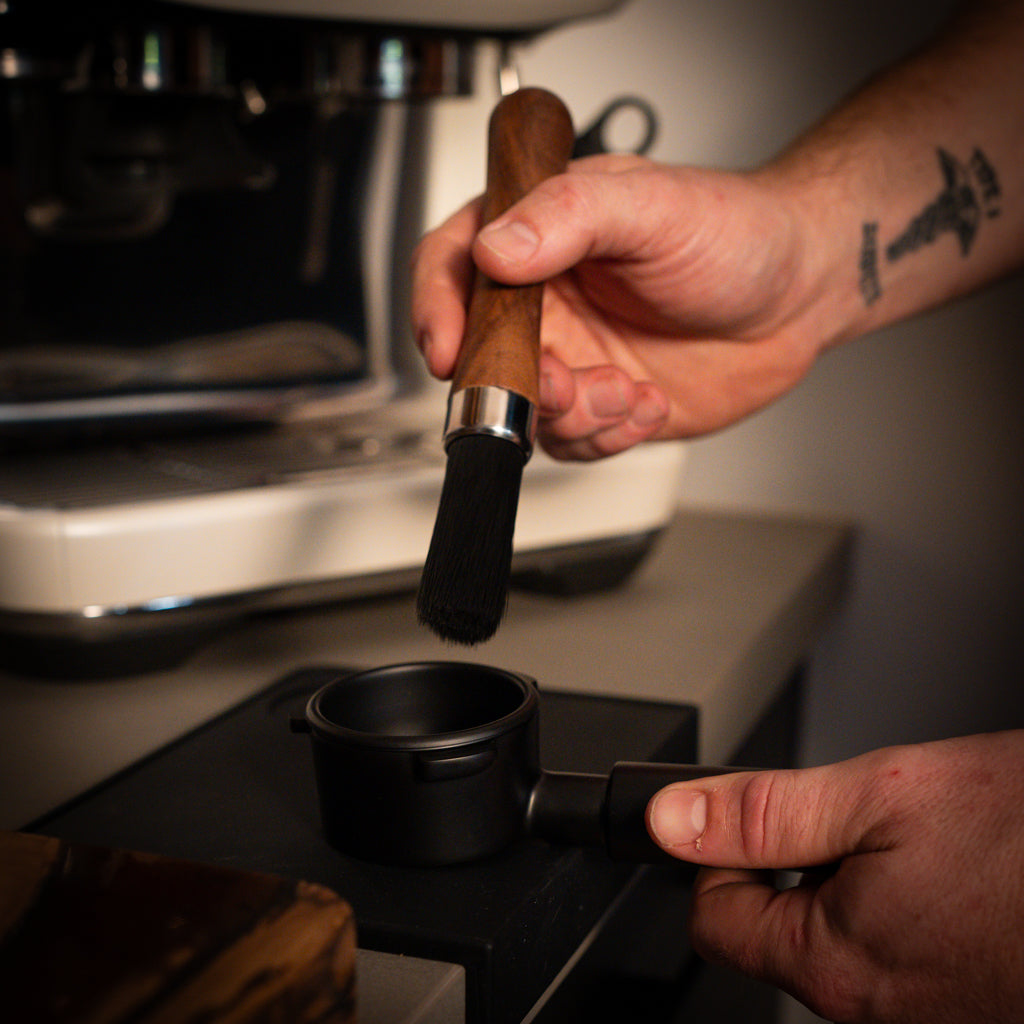 Coffee Cleaning Brush being used with Black Breville Portafilter