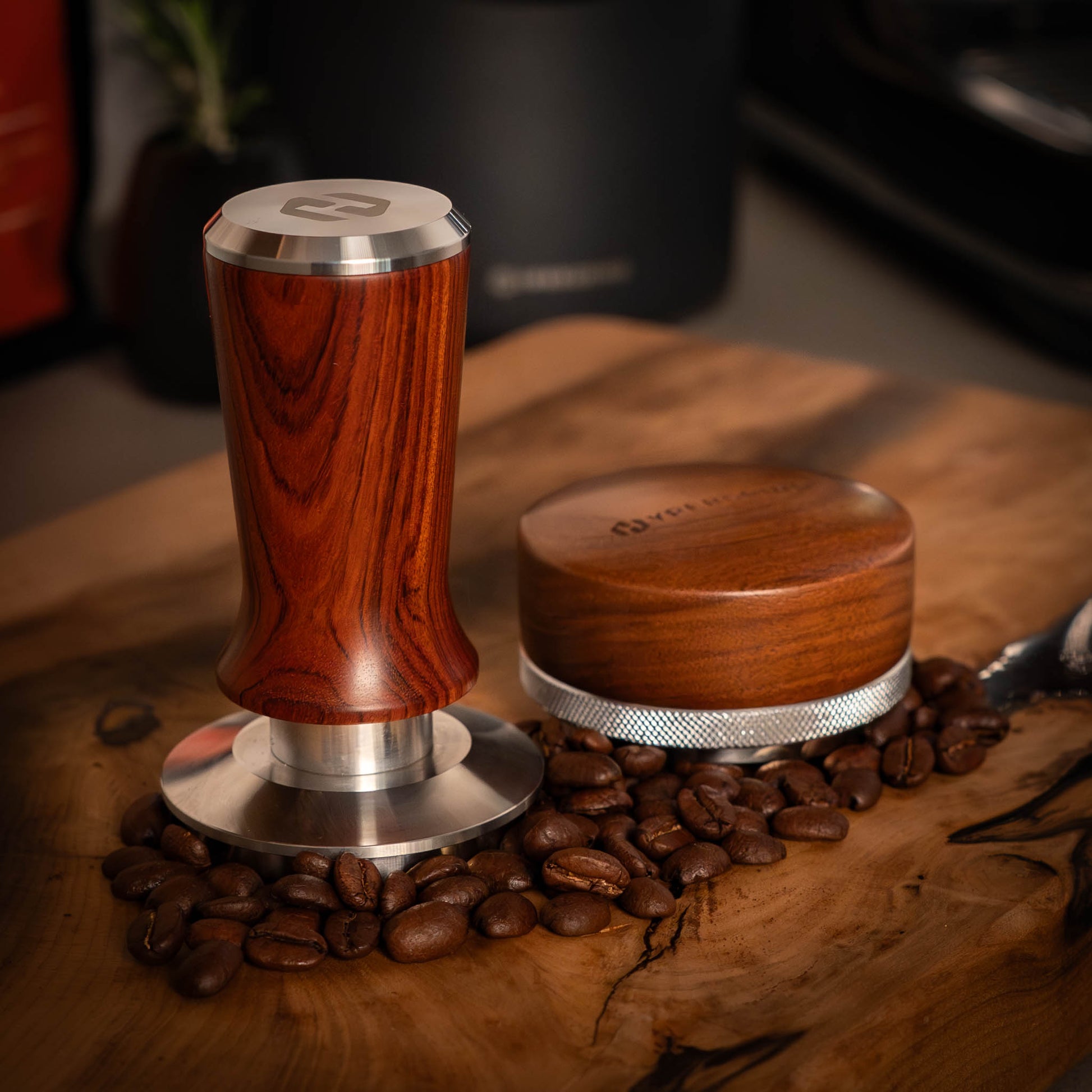Wooden coffee tamp and distributor
 on a wooden surface with coffee beans.